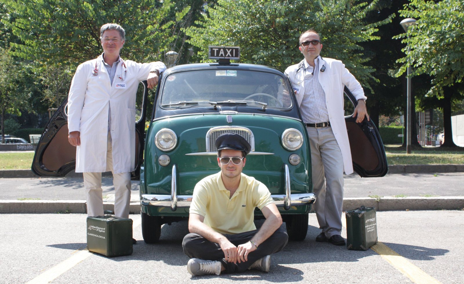 Lo staff di Medisport Figino in camice accanto alla Fiat 600 Multipla Taxi verde del 1962