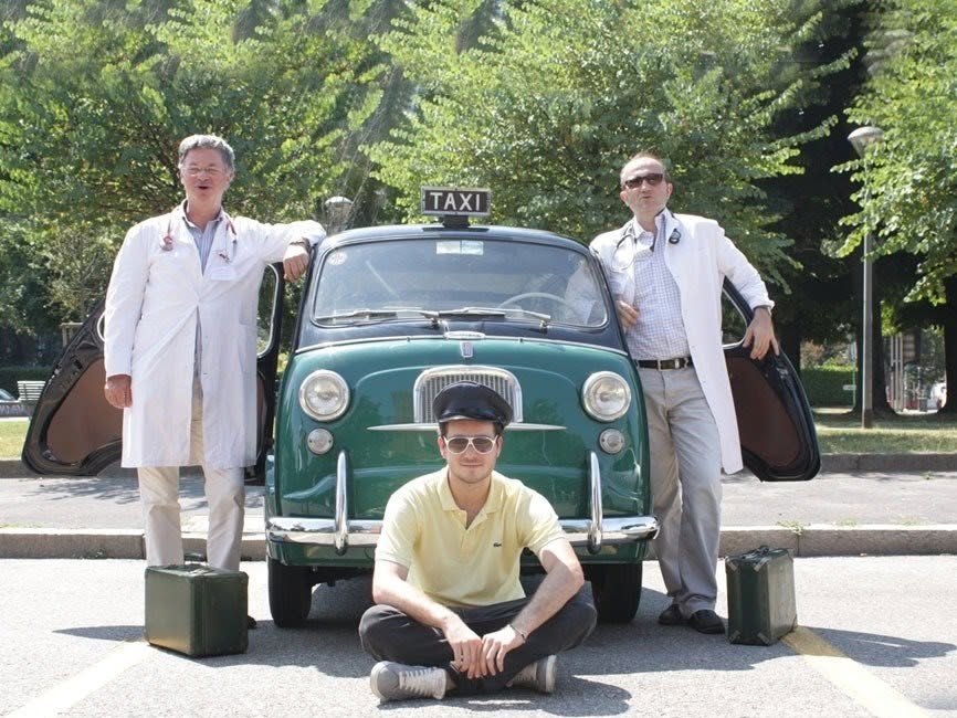Lo staff di Medisport Figino in camice accanto alla Fiat 600 Multipla Taxi verde del 1962